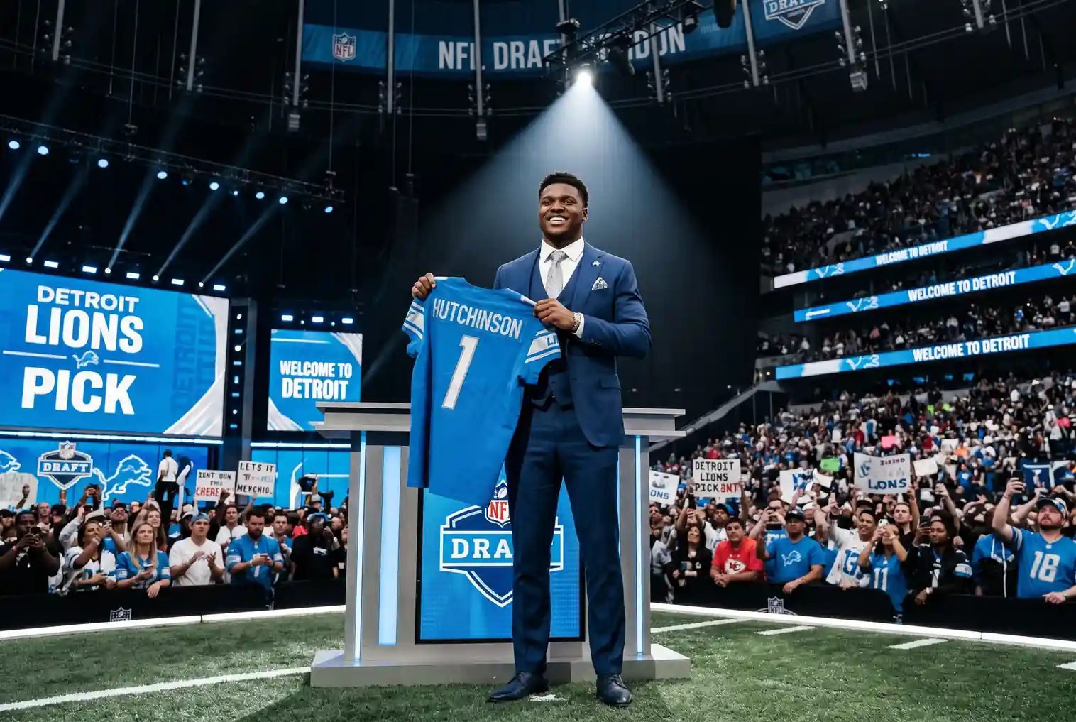NFL Draft pick announcement moment with a player holding up a jersey on stage